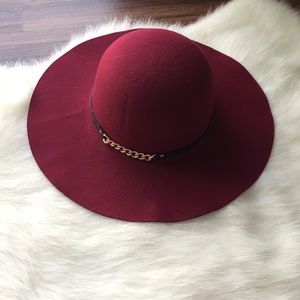 Cranberry wide brimmed hat with gold chain.